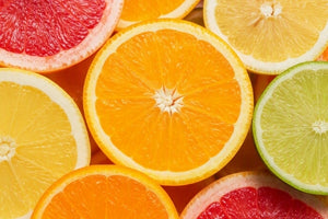 A close-up flat lay of colorful citrus fruit slices, including orange, grapefruit, lime, and lemon, filling the frame.