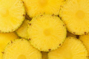 Close-up of bright yellow pineapple slices filling the frame.