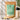 A stand-up pouch of Kiwi Nutrition Pea Protein Isolate in Creamy Vanilla flavor, displayed alongside a shaker bottle, loose powder, vanilla beans, and a flower on a light neutral background with product feature icons on the left.