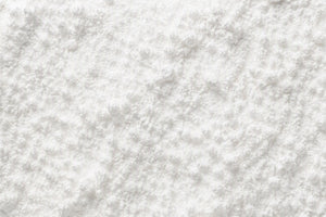 A close-up texture shot of a white Nicotinamide Riboside Chloride Powder