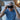 Man putting on a black sleep mask in a bedroom setting
