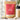 A stand-up pouch of Kiwi Nutrition Whey Protein in Creamy Vanilla flavor, shown on a marble surface with a shaker bottle, spoonful of powder, vanilla beans, and a flower. The package has a kraft brown exterior with a large pink label and a cream band near the bottom.